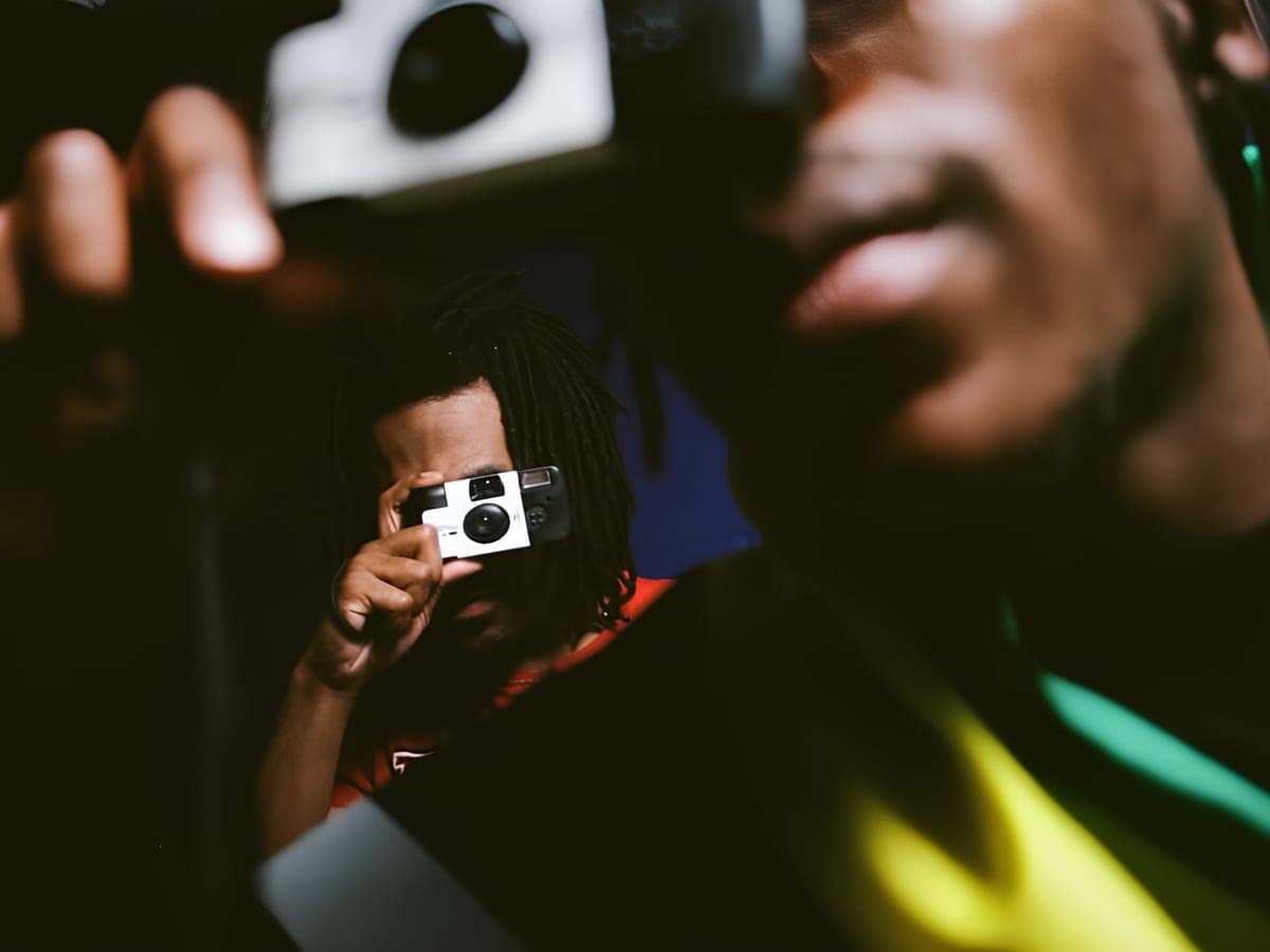 Person fotografiert bei einer Veranstaltung mit einer bedruckten Einwegkamera